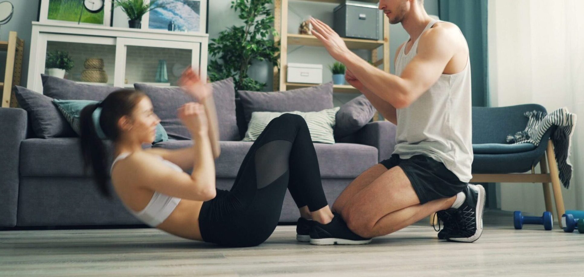 A couple exercising together at home with sit-ups and motivation.